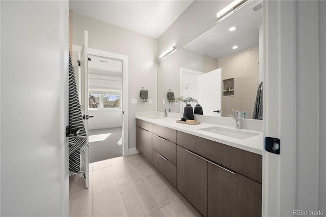 bathroom featuring a sink, tile patterned floors, double vanity, and recessed lighting