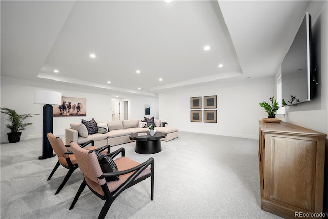 living area with a tray ceiling, light carpet, baseboards, and recessed lighting
