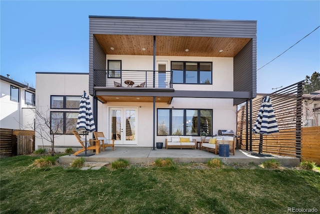 rear view of property featuring a balcony, french doors, stucco siding, and outdoor lounge area