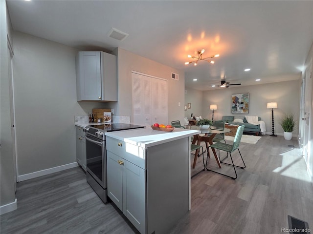 1250 S Monaco Pkwy Unit 17, Denver, CO 80224 - kitchen featuring stainless steel electric range, wood finished floors, baseboards, open floor plan, and recessed lighting