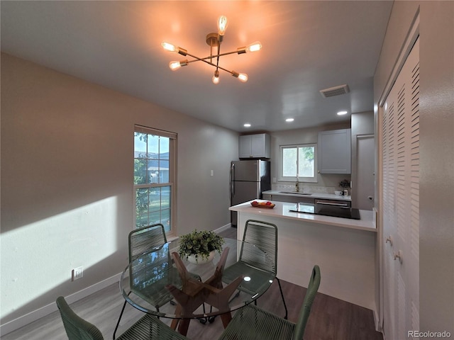 1250 S Monaco Pkwy Unit 17, Denver, CO 80224 - dining room featuring a chandelier, light wood-style flooring, baseboards, plenty of natural light, and recessed lighting