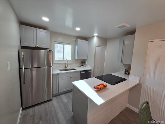 1250 S Monaco Pkwy Unit 17, Denver, CO 80224 - kitchen with freestanding refrigerator, a sink, dishwasher, light wood-style floors, and black electric stovetop