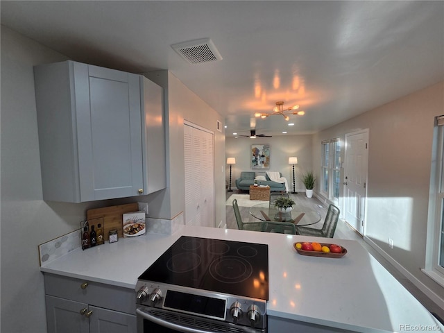 1250 S Monaco Pkwy Unit 17, Denver, CO 80224 - kitchen with stainless steel range with electric cooktop, light countertops, gray cabinetry, ceiling fan, and open floor plan