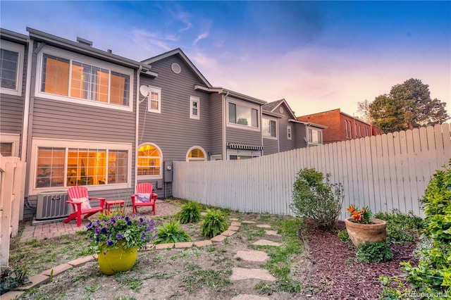 232 W 5th Ave, Denver, CO 80204 - back of house at dusk with central AC, a patio area, and fence