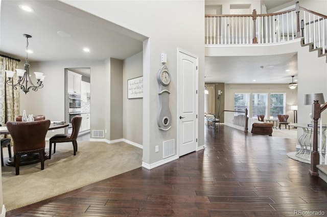 entrance foyer with wood-type flooring and ceiling fan with notable chandelier