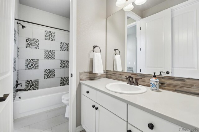 full bathroom with toilet, tiled shower / bath combo, vanity, and tile patterned floors