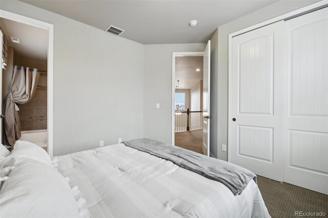 bedroom with ensuite bath, a closet, and carpet