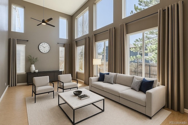 10774 Chadsworth Ln, Highlands Ranch, CO 80126 - living area featuring a high ceiling, a ceiling fan, light wood finished floors, and baseboards