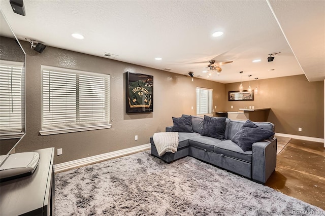 10774 Chadsworth Ln, Highlands Ranch, CO 80126 - living room featuring a textured wall, recessed lighting, baseboards, concrete flooring, and a textured ceiling