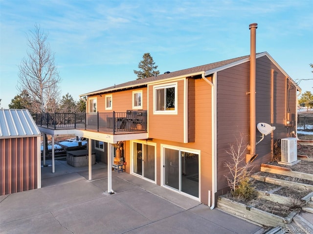 rear view of property with ac unit, a patio area, a balcony, and a jacuzzi