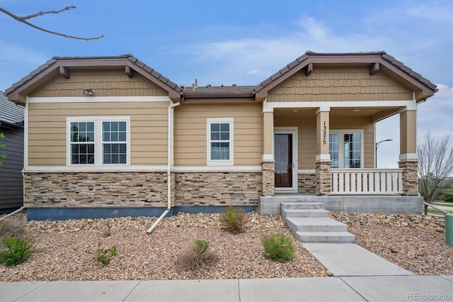 craftsman house with covered porch and stone siding