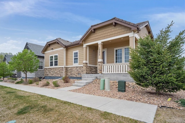 craftsman inspired home with a porch and stone siding