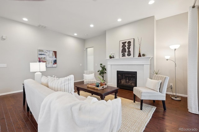 living room with baseboards, recessed lighting, a glass covered fireplace, and dark wood-style floors