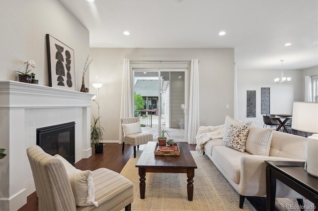 living room with an inviting chandelier, recessed lighting, baseboards, and wood finished floors