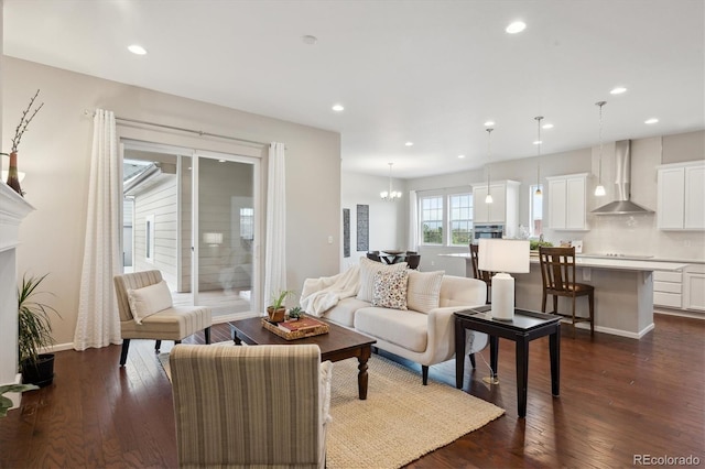living area featuring recessed lighting, dark wood finished floors, and a notable chandelier