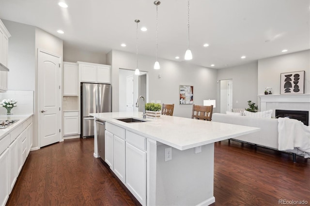 kitchen with dark wood-style floors, recessed lighting, light countertops, a sink, and appliances with stainless steel finishes