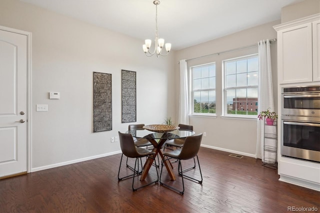 dining space with baseboards, dark wood finished floors, and a chandelier