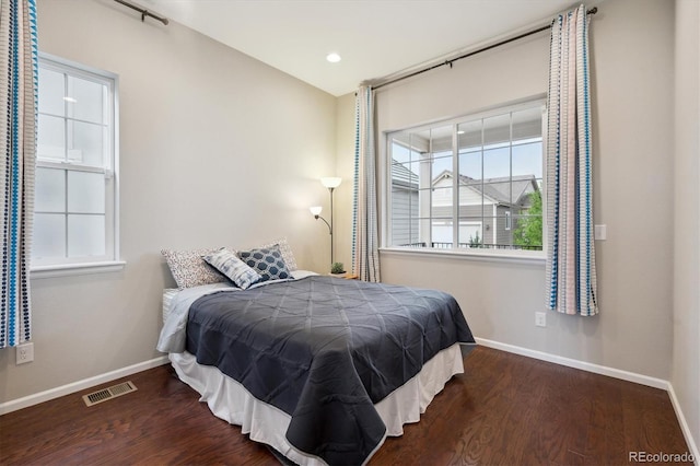 bedroom featuring baseboards, wood finished floors, and visible vents