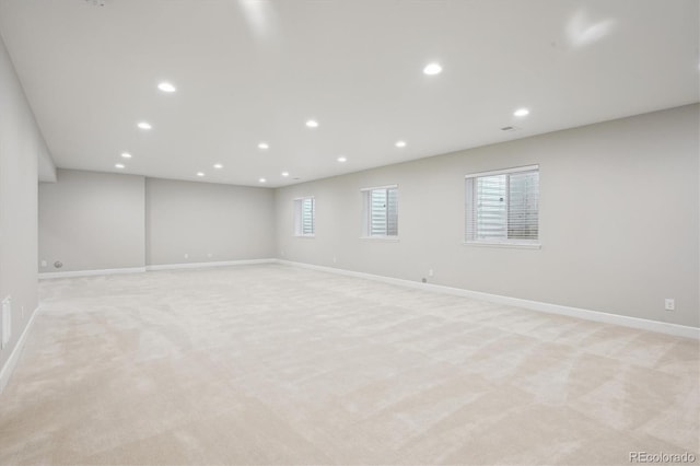 basement featuring baseboards, recessed lighting, and light carpet