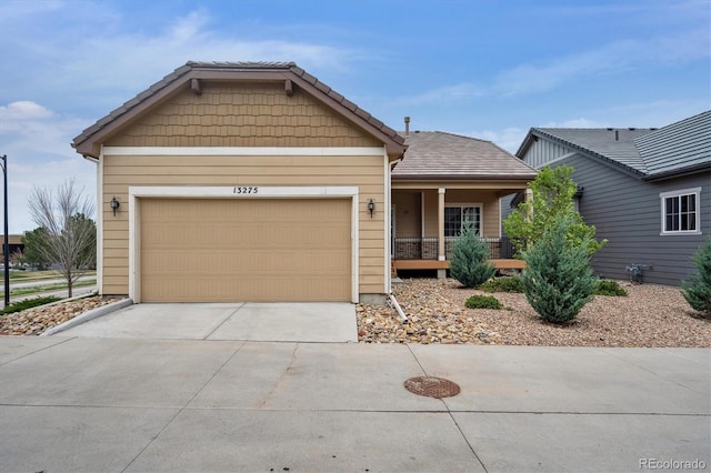 view of front facade featuring covered porch, driveway, and a garage