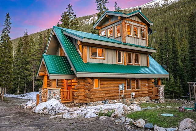 50 Pine St, Empire, CO 80438 - back of property at dusk with metal roof, a forest view, log exterior, and a mountain view