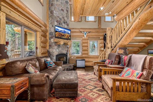 50 Pine St, Empire, CO 80438 - living area featuring log walls, a towering ceiling, stairway, wood finished floors, and a stone fireplace