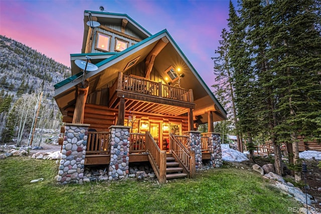 50 Pine St, Empire, CO 80438 - back of property at dusk featuring a porch, board and batten siding, a balcony, log exterior, and a mountain view