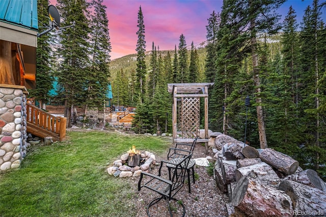 50 Pine St, Empire, CO 80438 - yard at dusk with an outdoor fire pit, a yard, and a view of trees