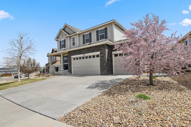 4830 S Versailles St, Aurora, CO 80015 - view of front of home with driveway, a garage, and stone siding