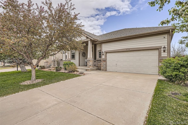 view of front of home featuring concrete driveway, a front lawn, a garage, and covered porch