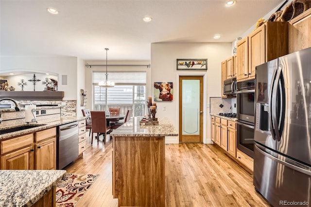 kitchen with appliances with stainless steel finishes, a sink, decorative backsplash, a chandelier, and recessed lighting