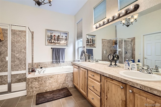 full bath featuring a shower stall, tile patterned flooring, a bath, a chandelier, and double vanity