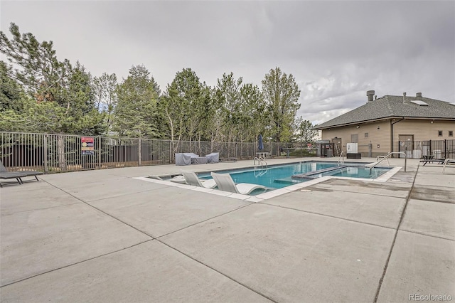 community pool featuring a patio area and fence