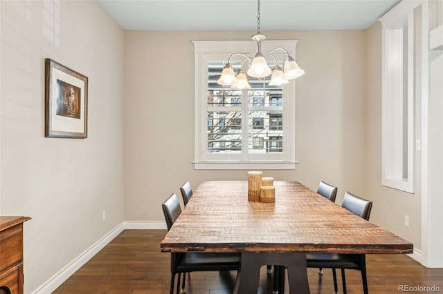 dining area with dark wood-style floors, baseboards, and a notable chandelier