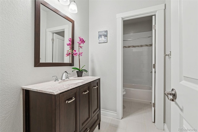 bathroom with toilet, baseboards, vanity, and tile patterned floors