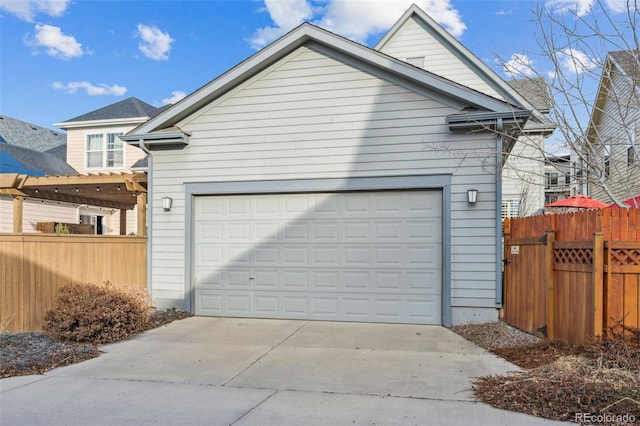 garage featuring fence and driveway