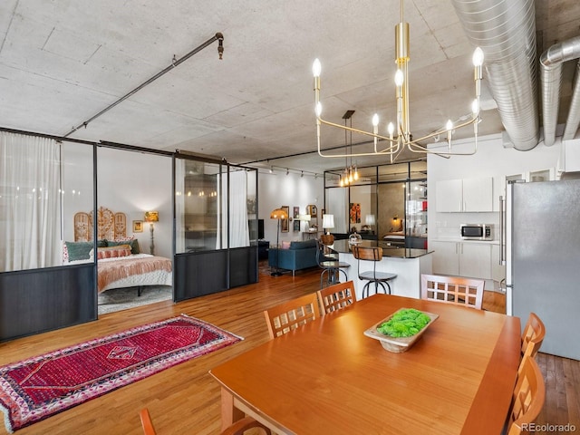 1499 Blake St Unit 3U, Denver, CO 80202 - dining area featuring wood finished floors and a chandelier