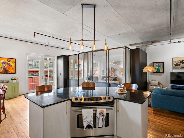 1499 Blake St Unit 3U, Denver, CO 80202 - kitchen with electric stove, open floor plan, light wood-type flooring, and dark stone counters