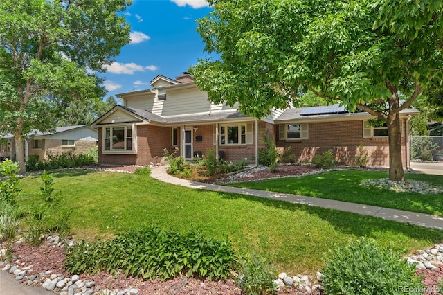 6906 S Sycamore St, Littleton, CO 80120 - view of front of home with brick siding, solar panels, and a chimney