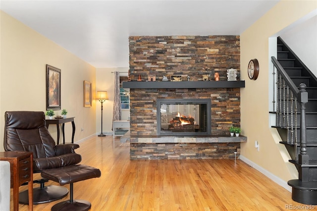 6906 S Sycamore St, Littleton, CO 80120 - living area featuring wood finished floors, stairs, and a stone fireplace