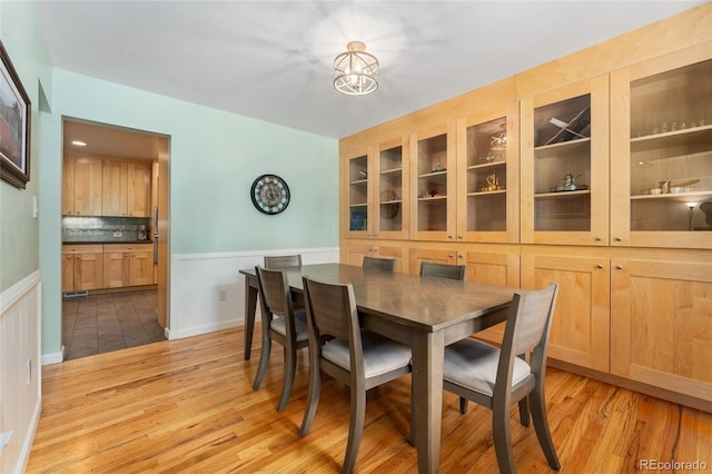 6906 S Sycamore St, Littleton, CO 80120 - dining space featuring wainscoting, light wood-type flooring, and a chandelier