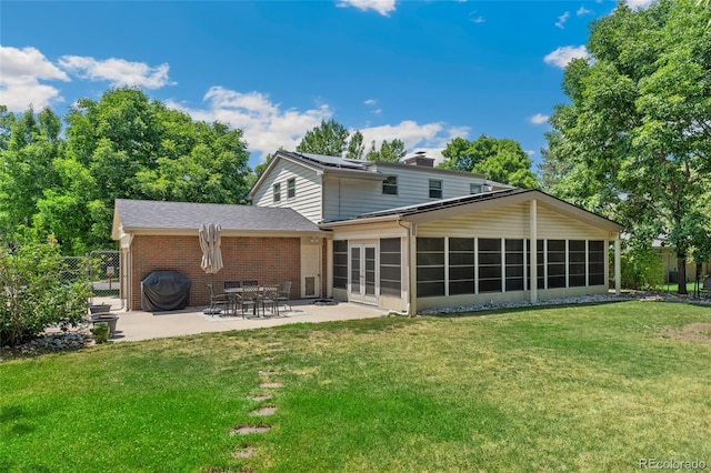 6906 S Sycamore St, Littleton, CO 80120 - back of house with brick siding, french doors, a patio area, roof mounted solar panels, and a chimney