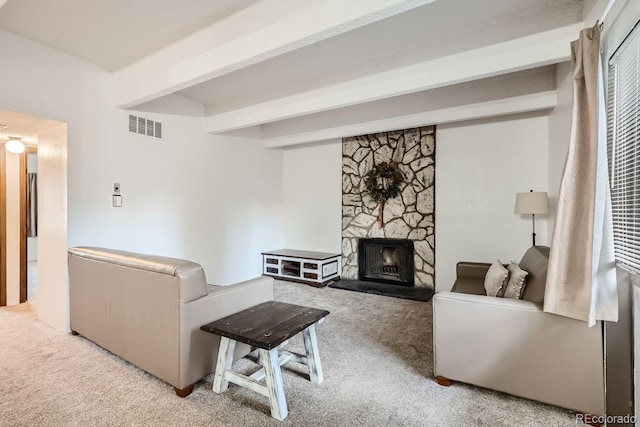 living room featuring beamed ceiling, a stone fireplace, and light carpet