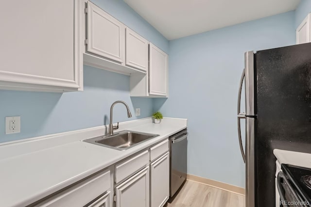 kitchen featuring white cabinetry, sink, light hardwood / wood-style flooring, and stainless steel appliances