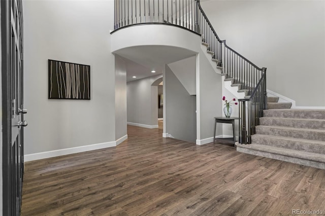 7119 S Riviera St, Aurora, CO 80016 - entrance foyer featuring arched walkways, a high ceiling, wood finished floors, and stairs