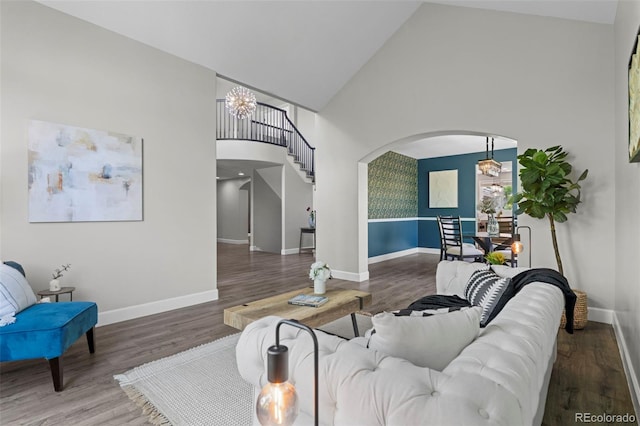 7119 S Riviera St, Aurora, CO 80016 - living area with arched walkways, high vaulted ceiling, wood finished floors, a chandelier, and stairway