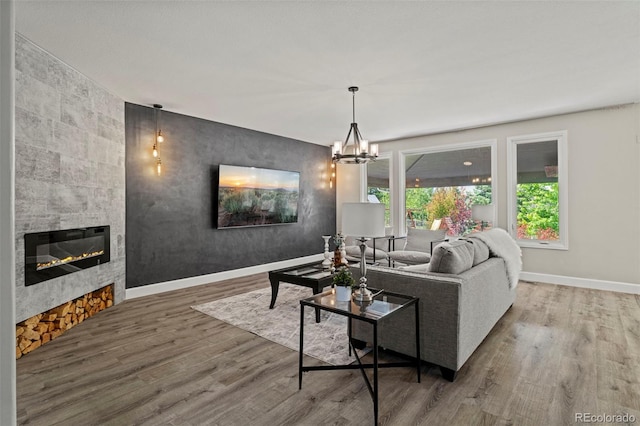 7119 S Riviera St, Aurora, CO 80016 - living room with wood finished floors, a tiled fireplace, and a chandelier