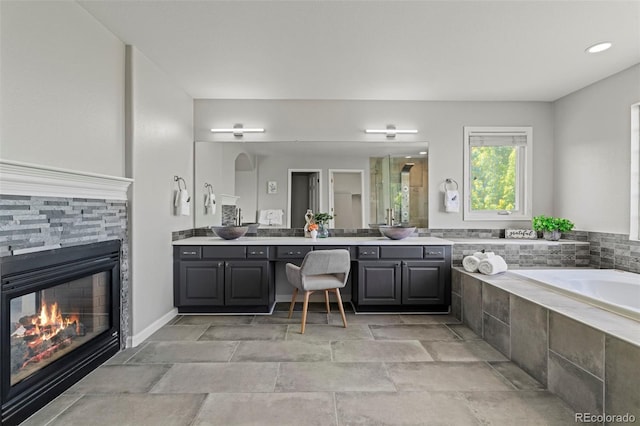7119 S Riviera St, Aurora, CO 80016 - full bath featuring vanity, a bath, a stone fireplace, and stone finish flooring