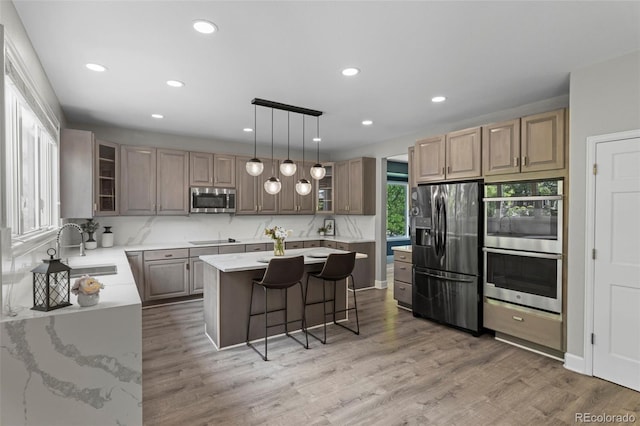 7119 S Riviera St, Aurora, CO 80016 - kitchen featuring appliances with stainless steel finishes, recessed lighting, a center island, glass insert cabinets, and a kitchen breakfast bar