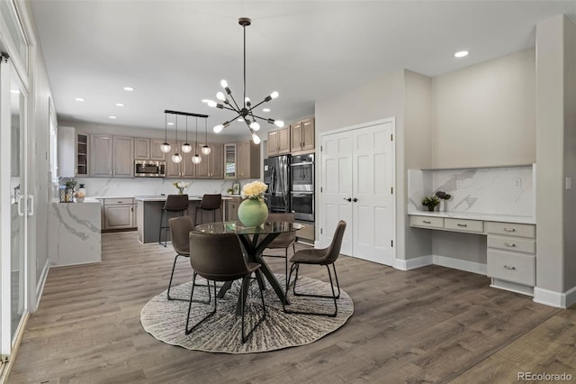 7119 S Riviera St, Aurora, CO 80016 - dining area with a chandelier, recessed lighting, built in desk, and wood finished floors